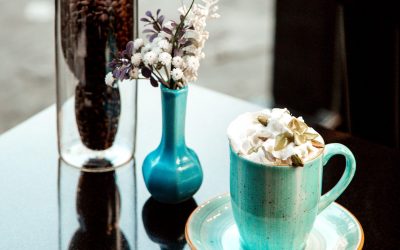 hot cup of coffee with cream and pistachios